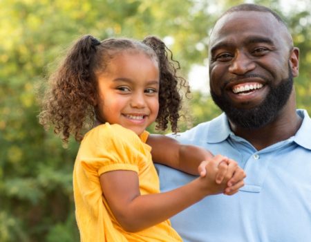 smiling father holding daughter