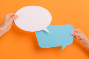 two speech bubbles being held next to each other