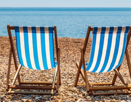 two blue and white deckchairs on the beach